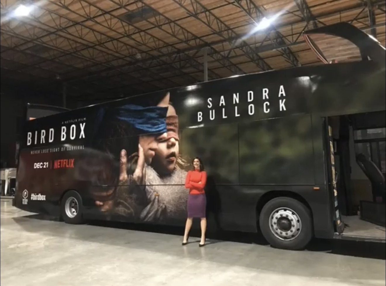 Melissa Beery standing beside the finished Bird Box bus in a warehouse before launch